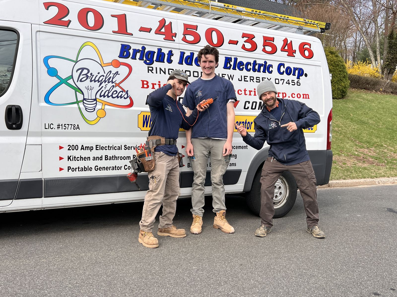 The Bright Ideas Electric crew at the company van, pointing at the phone number