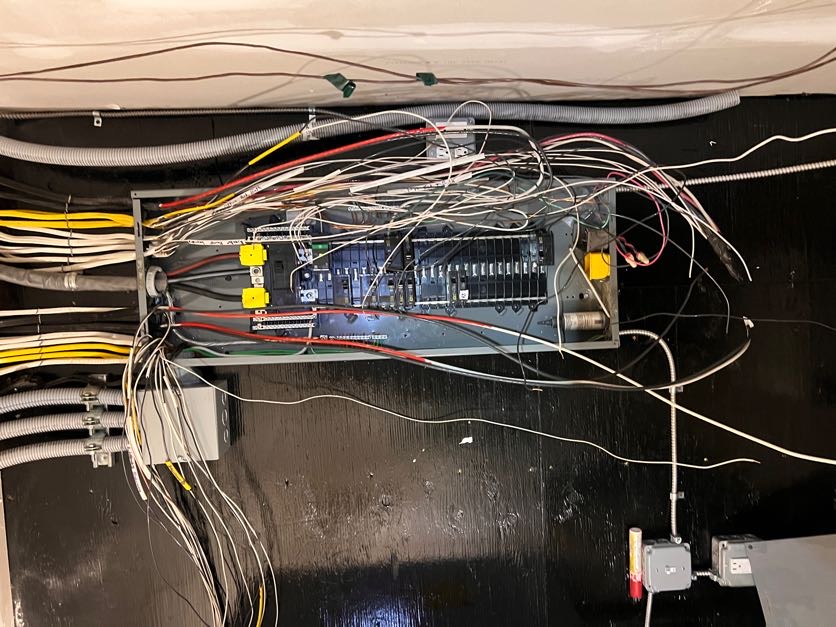 Before: outdated wiring and crowded electrical panel prior to replacement